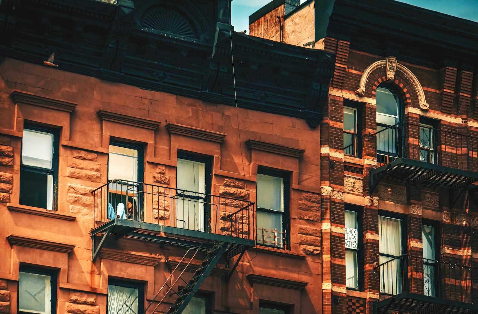Classic pre-war New York City brownstones with fire escape detail at golden hour